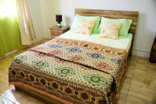 a bedroom with a bed with a quilt and pillows at Casa Mama in Quatre Bornes