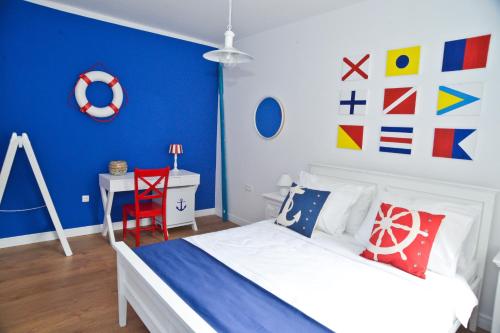 1 dormitorio con cama blanca y pared azul en Nautical rooms Old town, en Zadar