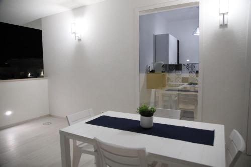 a white dining room with a white table and chairs at White Wall luxury rooms Scala dei turchi in Realmonte