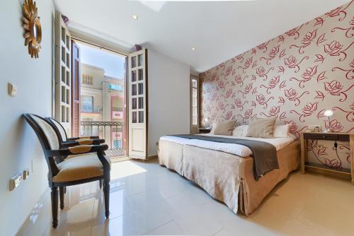1 dormitorio con 1 cama, 1 silla y 1 ventana en Holidays2Malaga Lazcano High Wifi & French balcony, en Málaga