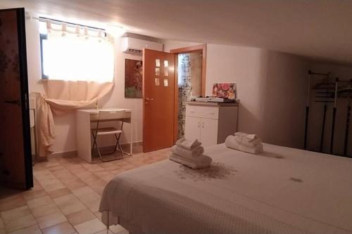 a bedroom with a bed and a desk and a window at Via Pisa 20 Mansarda in Bari