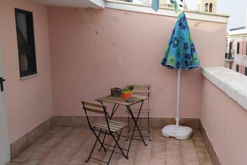 a table and chairs and an umbrella in a room at Via Pisa 20 Mansarda in Bari
