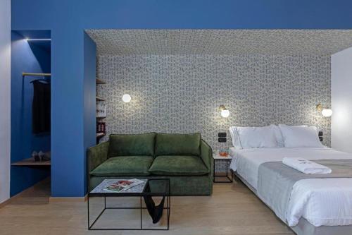 a bedroom with a bed and a green couch at Acro Urban Suites in Athens