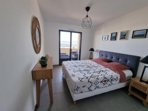 une chambre avec un lit, une table et une fenêtre dans l'établissement LoCorse - Superbe appartement T2 avec une belle vue mer, à Grosseto-Prugna