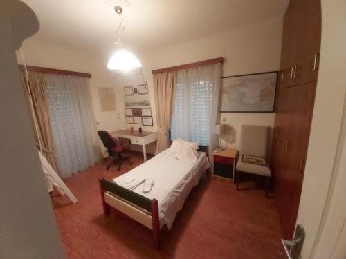 1 dormitorio con cama y escritorio. en Geranium Villa by the sea, en Kineta