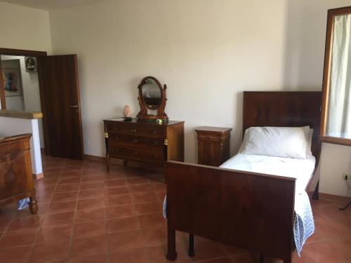 a bedroom with a bed and a mirror and a dresser at VILLA CLANI apartment in Colà di Lazise