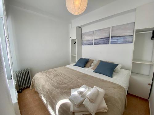 a bedroom with a large bed with blue pillows at Beautiful apartment in the centre of Nerja in Nerja