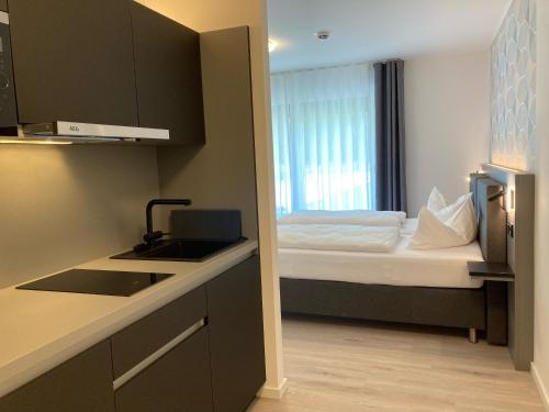 a small kitchen with a bed in a room at CAP1 Boardinghouse in Baesweiler