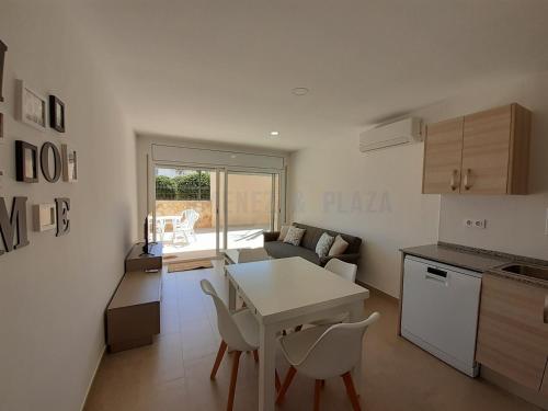 uma cozinha e sala de estar com mesa e cadeiras em Apartamentos Dins Mar Apto. 3 em Torredembarra