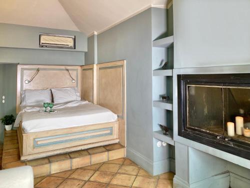 a small bedroom with a bed and a fireplace at Archontika Karamarlis in Makrinítsa
