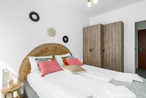 a bedroom with a large white bed with colorful pillows at Sleepway Apartments - Boho Dream in Poznań