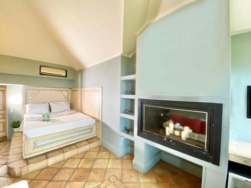 a bedroom with a fireplace and a bed at Archontika Karamarlis in Makrinítsa