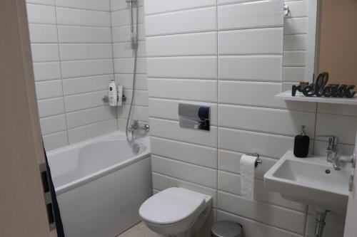 a white bathroom with a toilet and a sink at CityApart GranVia Marina - Cazare în Constanța, lângă stațiunea Mamaia in Constanţa