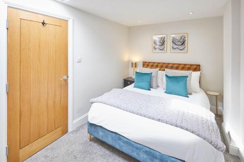 una camera da letto con un grande letto con cuscini blu di Host & Stay - The Milton a Saltburn-by-the-Sea