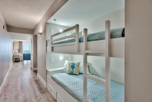 a bedroom with two bunk beds and a hallway at Pelican Beach Resort Destin in Destin