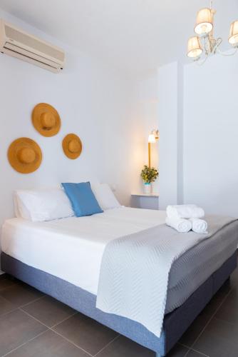 a bedroom with a white bed with towels on it at Ammos Sifnos Village in Platis Yialos Sifnos