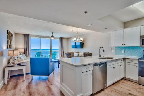 a kitchen with white cabinets and a view of the ocean at Pelican Beach Resort Destin in Destin