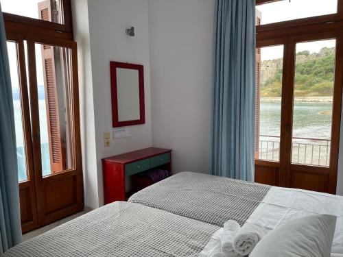 a bedroom with two beds and a window at Xenios Zeus Rooms in Koroni