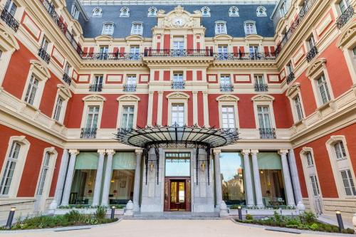 un bâtiment avec une horloge au sommet dans l'établissement Hôtel du Palais Biarritz, in The Unbound Collection by Hyatt, à Biarritz