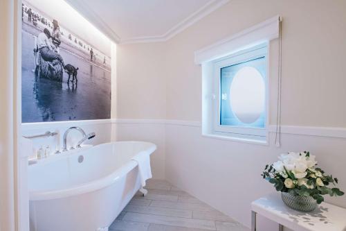 a white bath tub sitting next to a white wall at Hôtel du Palais Biarritz, in The Unbound Collection by Hyatt in Biarritz