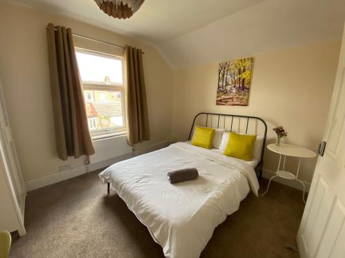 a bedroom with a large bed with yellow pillows at Edinburgh Place in Kettering