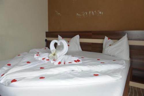 a bed with two white swans with hearts on it at Primus Hotel & Apartments in Vienna