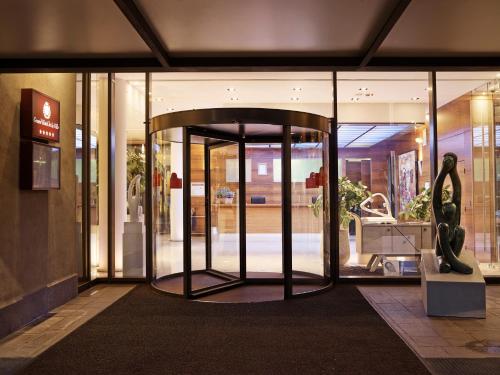 a store front with a revolving door in a building at Grand Hotel De La Ville in Parma