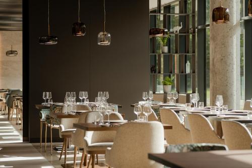 a dining room with tables and chairs and wine glasses at Radisson Resort Kołobrzeg in Kołobrzeg