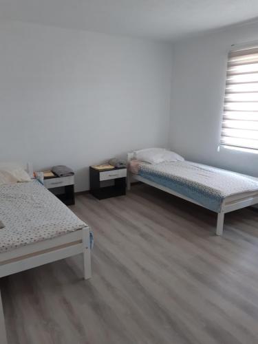 two beds in a room with wooden floors at AS guesthouse in Krževići