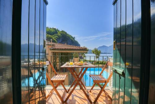 a balcony with a table and chairs and a pool at Aria di Breva in Lierna