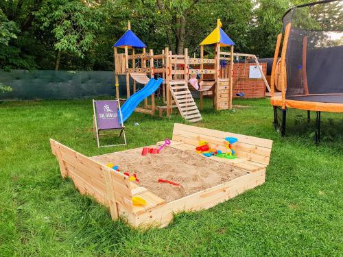 a sandbox in the grass next to a playground at LUXURY CAMP - 150 m od Suntago Park in Grabce-Towarzystwo