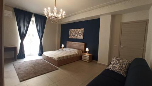 um quarto com uma cama com paredes azuis e um lustre em CasaVera apartment em Acireale