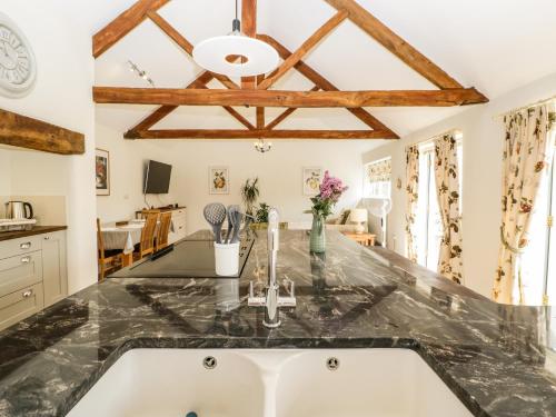 cocina con fregadero y encimera en Tom's Barn, en Yeovil