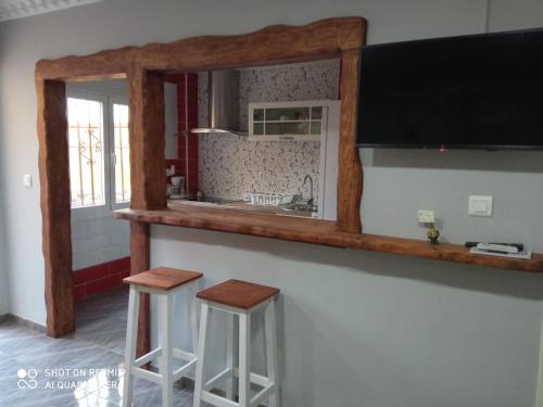 a kitchen with two stools and a large mirror at Casa La Maravilla in Jerez de la Frontera