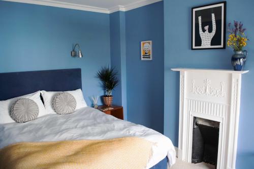 a blue bedroom with a bed and a fireplace at The Falstaff Hotel & Restaurant Ramsgate in Ramsgate