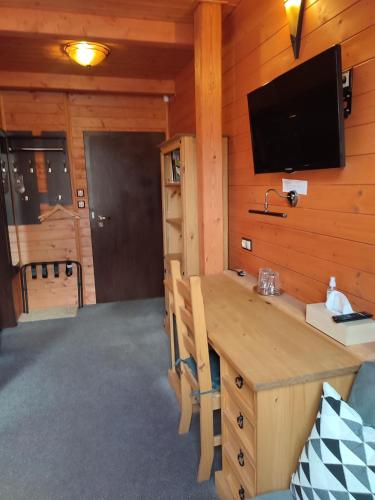 a room with a wooden desk and a tv on a wall at Nábřežní terasy in Žďár nad Sázavou