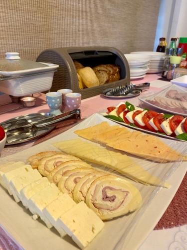 a table topped with cheese and fruit on a table at Pensiunea Rix Rooms in Focşani