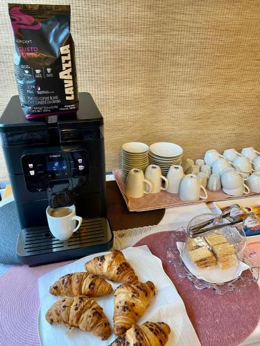 a table with a coffee maker and a plate of pastries at Pensiunea Rix Rooms in Focşani