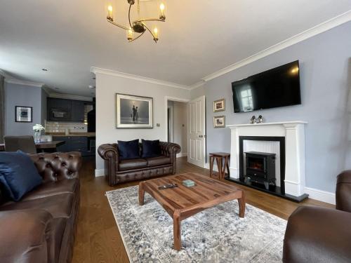 a living room with couches and a table and a fireplace at Park View in Keswick