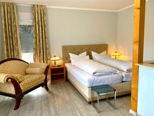 1 Schlafzimmer mit 2 Betten, einem Stuhl und einem Sofa in der Unterkunft Ratskeller Hotel & Restaurant Lindow in Lindow