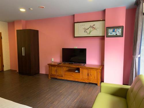 a living room with a tv and a couch at Grandma Yu's B&B in Yuchi