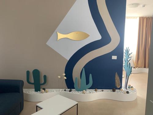 a living room with a fish mural on the wall at Hotel Lido in Follonica