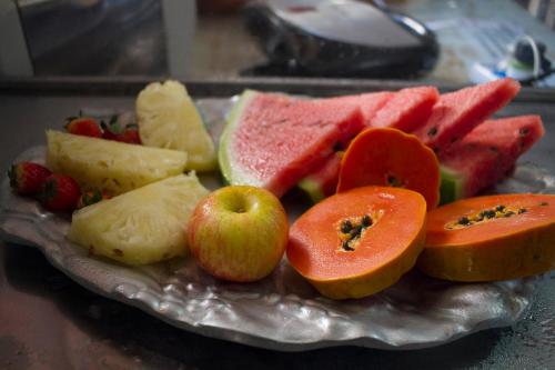 a plate of fruit and vegetables on a table at Pousada Lagoa in Belo Horizonte