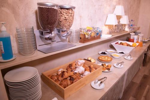 a kitchen counter with a variety of pastries on it at Hotel Della Rosa in Ancona