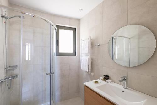 a bathroom with a shower and a sink and a mirror at Margo Beach Hotel in Gythio
