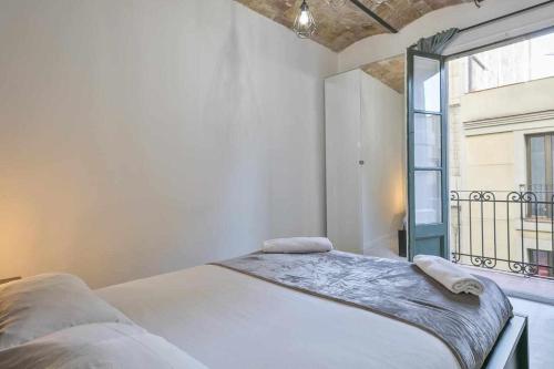 バルセロナにあるApartamento Alejandro en BCNの白いベッドルーム(ベッド1台、窓付)