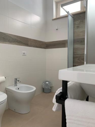 a white bathroom with a sink and a toilet at Apartment Lido in Follonica