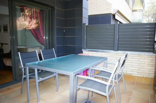 トッサ・デ・マールにあるApartamento PR 39 terraza y piscina Tossa de Marの青いテーブルと椅子が備わるパティオ