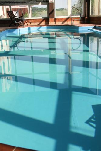 a swimming pool with blue water in a building at Art Hotel Pandos in Tabiano