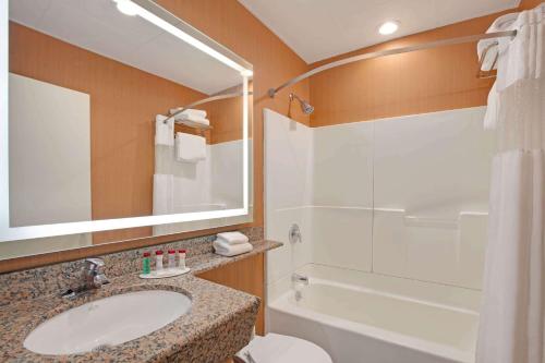 a bathroom with a sink, toilet and bathtub at Ramada by Wyndham Bronx in Bronx